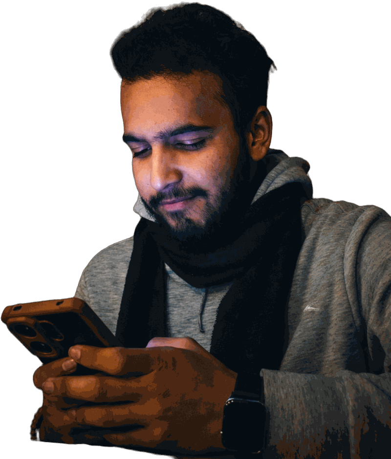 Aswin Paudel in a grey hoodie and black scarf, smiling at his phone